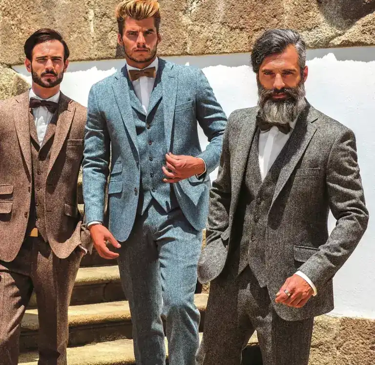 Three men in tweed three-piece suits standing on stone steps